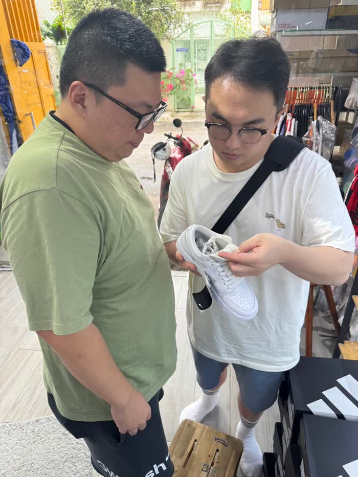 市場考察照片：兩位訪客在店內近距離觀察鞋款